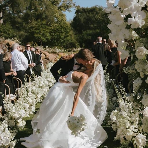Groom dipping the bride for a kiss at a garden wedding ceremony